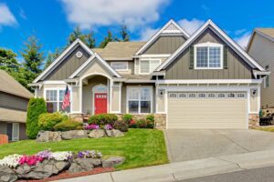 large suburban home with beautiful landscaping and red door